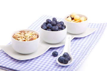 fresh blueberry with porcelain spoon, corn flakes and serviette.