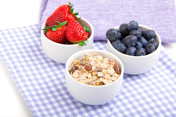 fresh blueberry, strawberries, corn flakes in the porcelain bowl