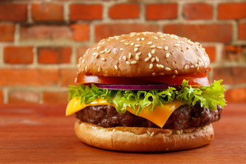 Hamburger on table with red brick wall background