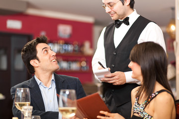 Waiter serving a couple at restaurant