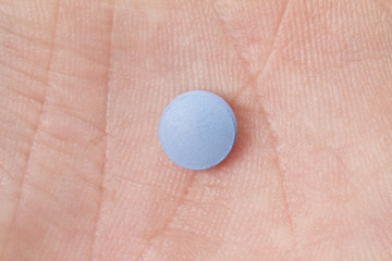 small medical pill in the palm of a hand