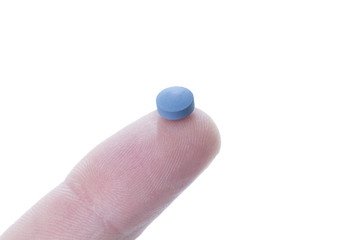 a blue pill balancing on the tip of a human finger