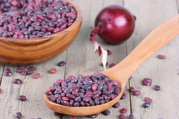 Red beans and onion on a wooden background