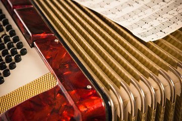 Red accordion and sheet music, closeup
