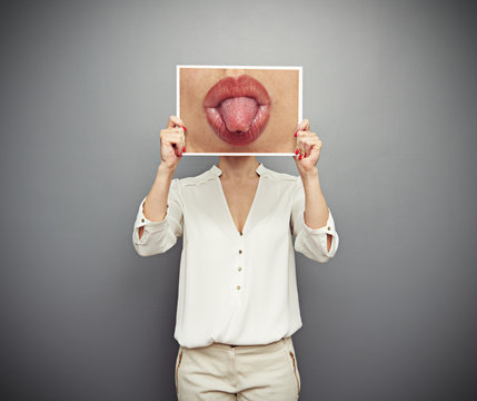 woman holding picture with lips and tongue