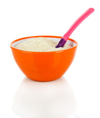 Powdered milk in bowl and spoon for baby isolated on white