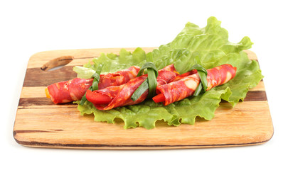 Salami rolls on wooden board, isolated on white