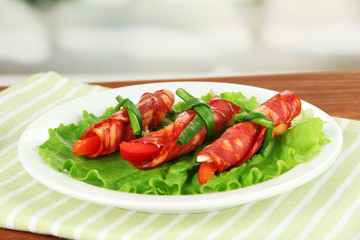 Salami rolls on white plate on bright background