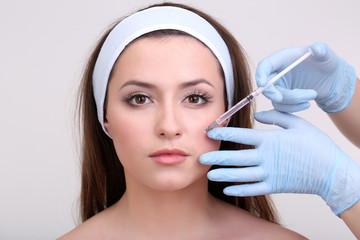 Young woman receiving plastic surgery injection