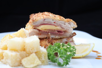 Chicken cordon bleu on black background