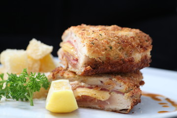 Chicken cordon bleu on black background