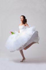Fototapeta na wymiar beautiful bride jumping in studio
