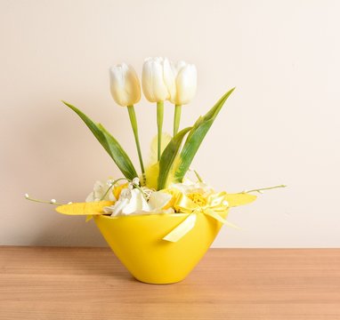 Decorative white tulips in the yellow flowerpot.