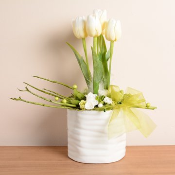 Decorative white tulips in the white flowerpot.