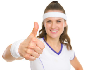 Closeup on smiling female tennis player showing thumbs up