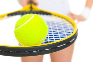 Closeup on female tennis player holding racket with ball