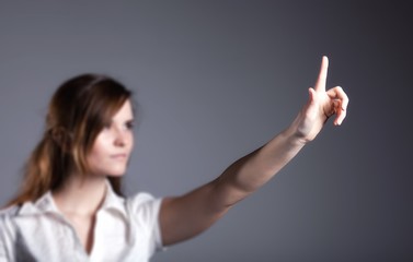 Woman with raised hand and one finger dark background