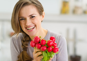 Portrait of smiling young woman with bunch of radishes - Powered by Adobe