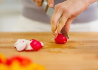 Closeup on woman cutting radishes