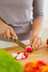 Closeup on woman cutting radishes