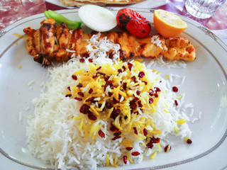 An Iranian grilled chicken and tomatoes served on rice in white