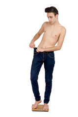 Fototapeta premium Man weighing himself on scale and scared of how skinny he is.