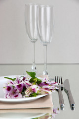 Festive table setting with flowers on grey background
