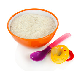 Powdered milk in bowl with spoon and nipple for baby isolated