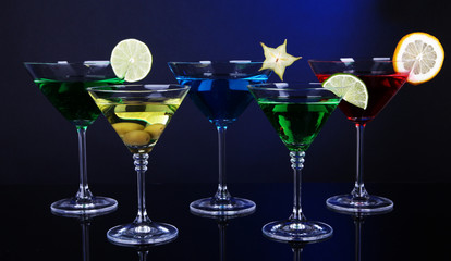 Alcoholic cocktails in martini glasses on dark blue background