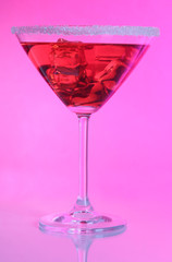Red cocktail in martini glass  on pink background