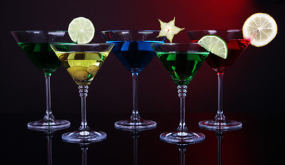 Alcoholic cocktails in martini glasses on dark red background