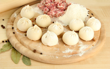 Raw dumplings, ingredients and dough, on wooden table