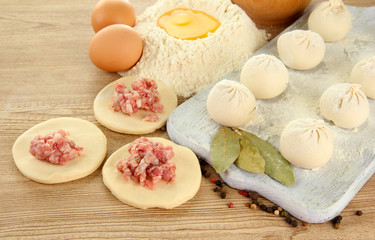 Raw dumplings, ingredients and dough, on wooden table