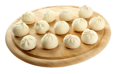 Raw khinkali on wooden desk, isolated on white