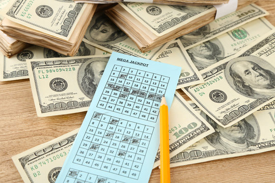 Lottery ticket,money and pencil on wooden background