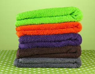 Pile of colorful towels, on green background