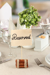 Reserved sign on restaurant table with empty dishes and glasses