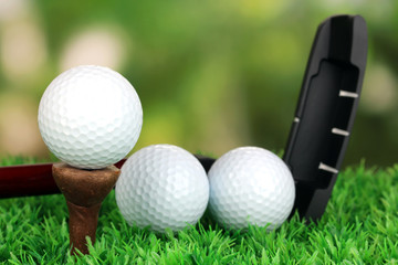Golf ball and driver on green grass outdoor close up