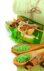 Hand-made soap and sea salt on bamboo mat, isolated on white