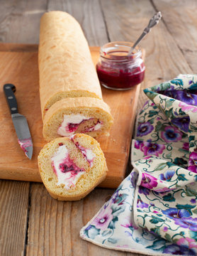 Homemade swiss roll with whipped cream and black currant jam