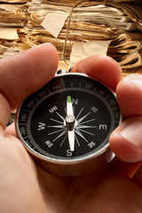 Hand holding compass on document folders background