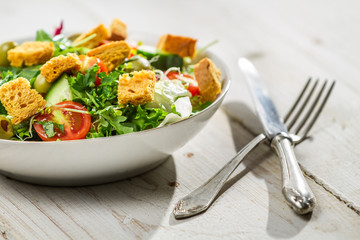 Fresh Caesar salad on old white table