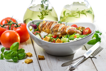 Fresh salad made of chicken, tomato, olive and fresh herbs