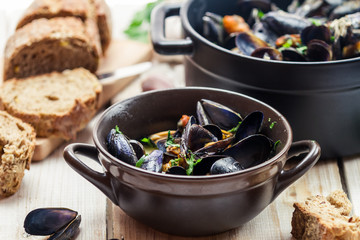 Mussels served in a sunny day with homemade bread