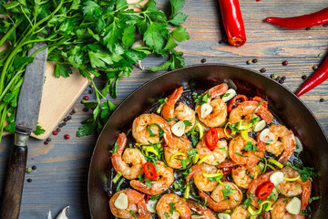 Shrimps fried on pan with fresh herbs