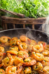 Hot shrimp fried in a pan with fresh herbs