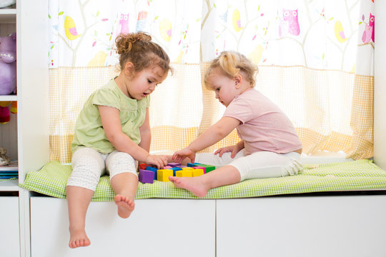 two kids sisters play together indoors