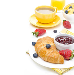 Breakfast with croissant, jam, fresh berries, coffee with milk