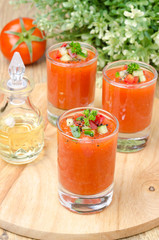 cold tomato soup gazpacho in portion glasses on a wooden board