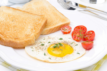 Fried eggs, fresh tomatoes and crunchy toast for breakfast